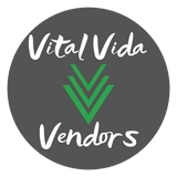 Medium gray circle with island font style in white with "Vital Vida" on top line and "Vendors" on bottom line with three V shapes stacked vertically in the color green between the two text lines